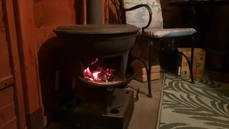 cast iron wood burning stove blazing in cosy outdoor wooden cabin kitchen