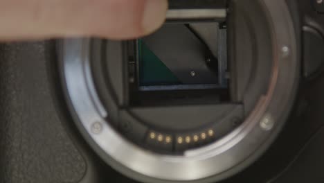Hand-flipping-up-mirror-of-DSLR-camera-and-revealing-broken-shutter-blades