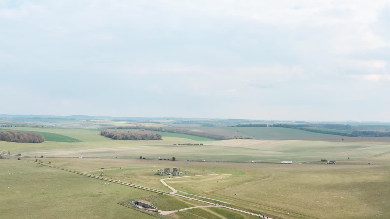 Wide rising circling drone shot of Stonehenge near A303 highway UK