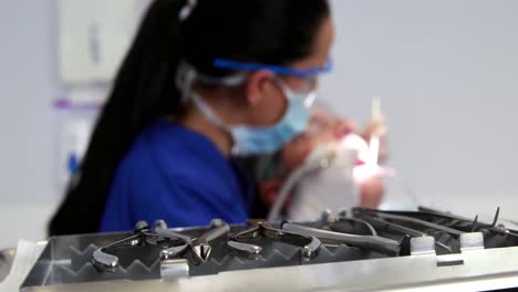 Dentist-examining-a-patients-teeth-in-the-dentists-chair