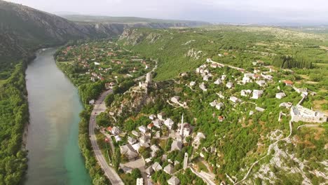 Eine-Luftaufnahme-Zeigt-Autos,-Die-Auf-Der-Straße-Zwischen-Dem-Fluss-Neretva-Und-Dem-Dorf-Pocitelj-Bosnia-.-Fahren