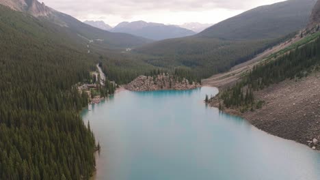 carrello aereo nella morena del lago turchese circondato da una foresta di pini, montagne rocciose canadesi al parco nazionale di banff, alberta, canada