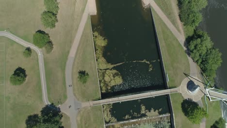 Vista-Aérea-De-Arriba-Hacia-Abajo-De-Un-Puente-Moderno-Sobre-Un-Desvío-De-Canal-Desde-Un-Río