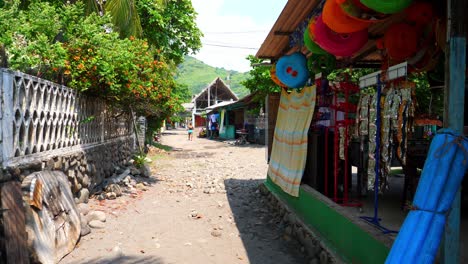 tiro completo, bocadillos colgados al costado de una casa de playa en la playa bitcoin en el salvador, méxico, una mujer caminando en la calle en un día soleado