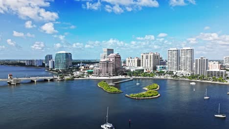 aerial: one flagler, phillips point building and west palm beach cityscape during the day in florida, usa, crane up drone shot