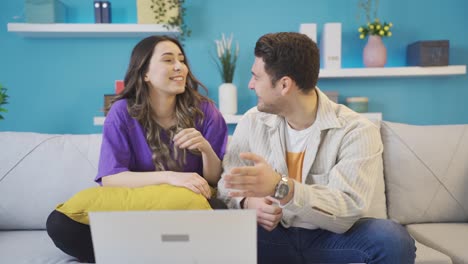 un joven feliz y una mujer enamorados viendo una película o video divertido y entretenido en casa.