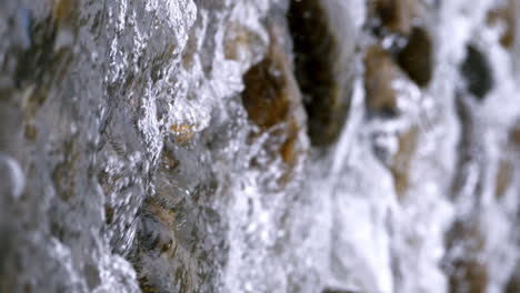 vertical de un claro arroyo que corre a través de rocas de piedra abundante río que fluye en cámara lenta