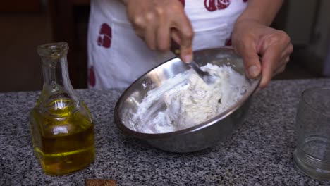 chef femenina mezclando masa de hojaldre harina huevos ingredientes de aceite en un tazón