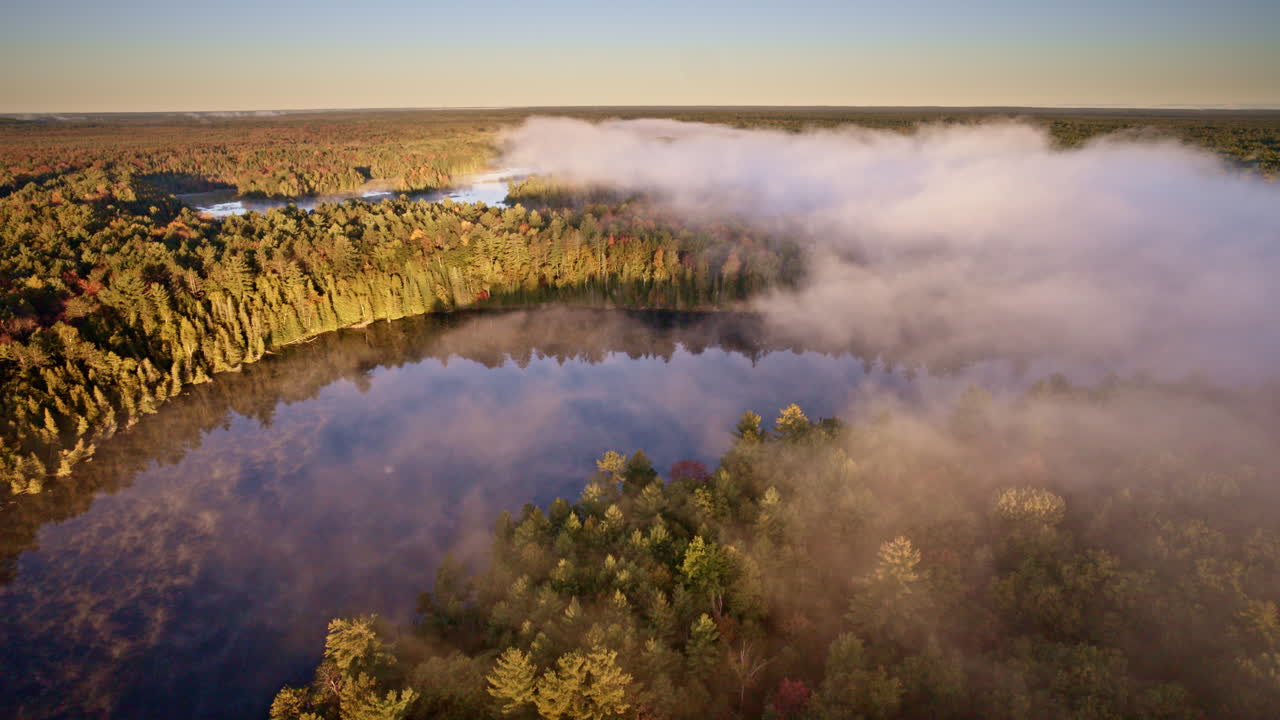 Cinematic aerial footage of water shrouded in dawn mist