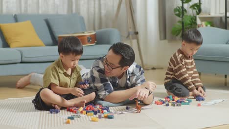 father and sons playing with building blocks