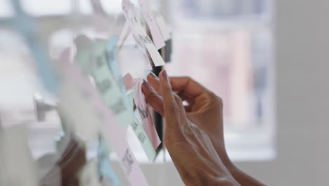 close up hand business woman using sticky notes brainstorming ideas problem solving with creative mind map planning strategy in office working on solution