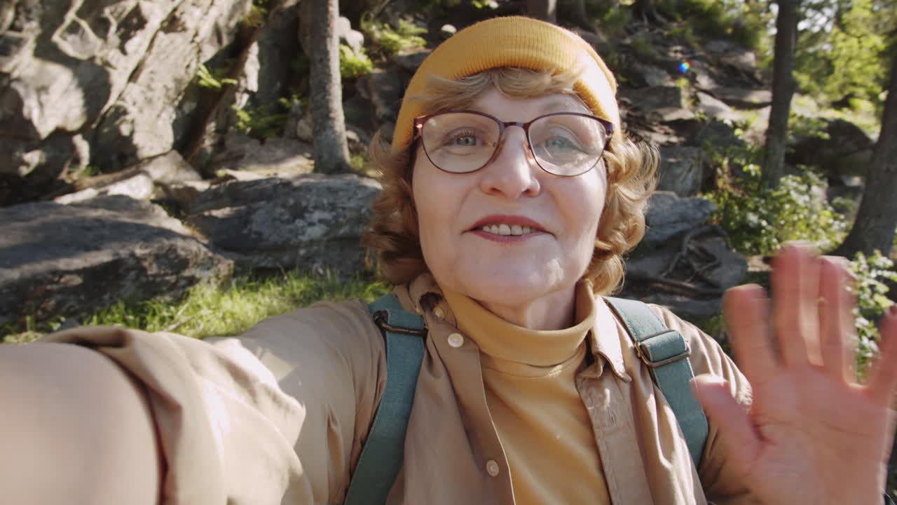 Donna anziana che fa trekking e si fa un selfie nella natura