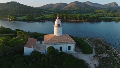 drone parallax around alcanada lighthouse at sunrise, stunning blue and green coastal landscape