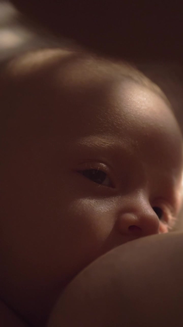 Madre che allatta un bambino assonnato di tre mesi