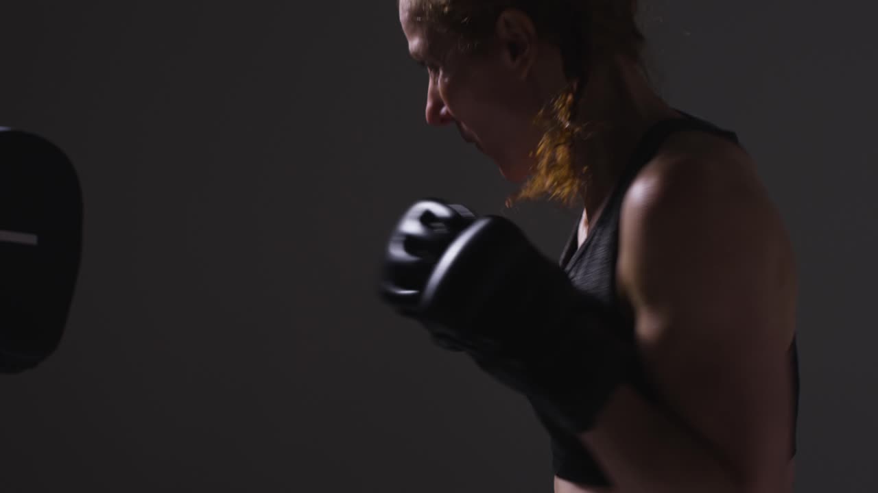 Close Up Studio Shot Of Two Mature Women Wearing Gym Fitness Clothing Exercising Boxing And Sparring Together 1