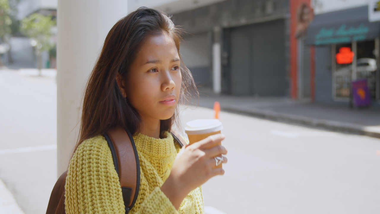 Teenage girl drinking coffee on street 4k