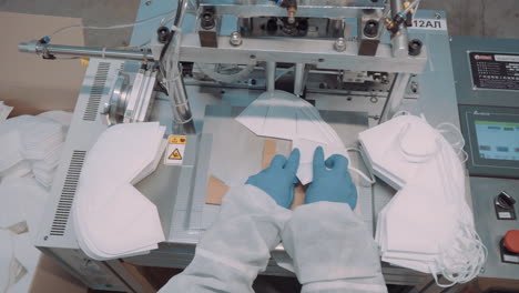 gluing the elastics to face masks, workers perform the operation with an automatic machine