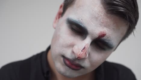 Man-with-face-paint-showing-creepy-look-at-the-camera,-closeup