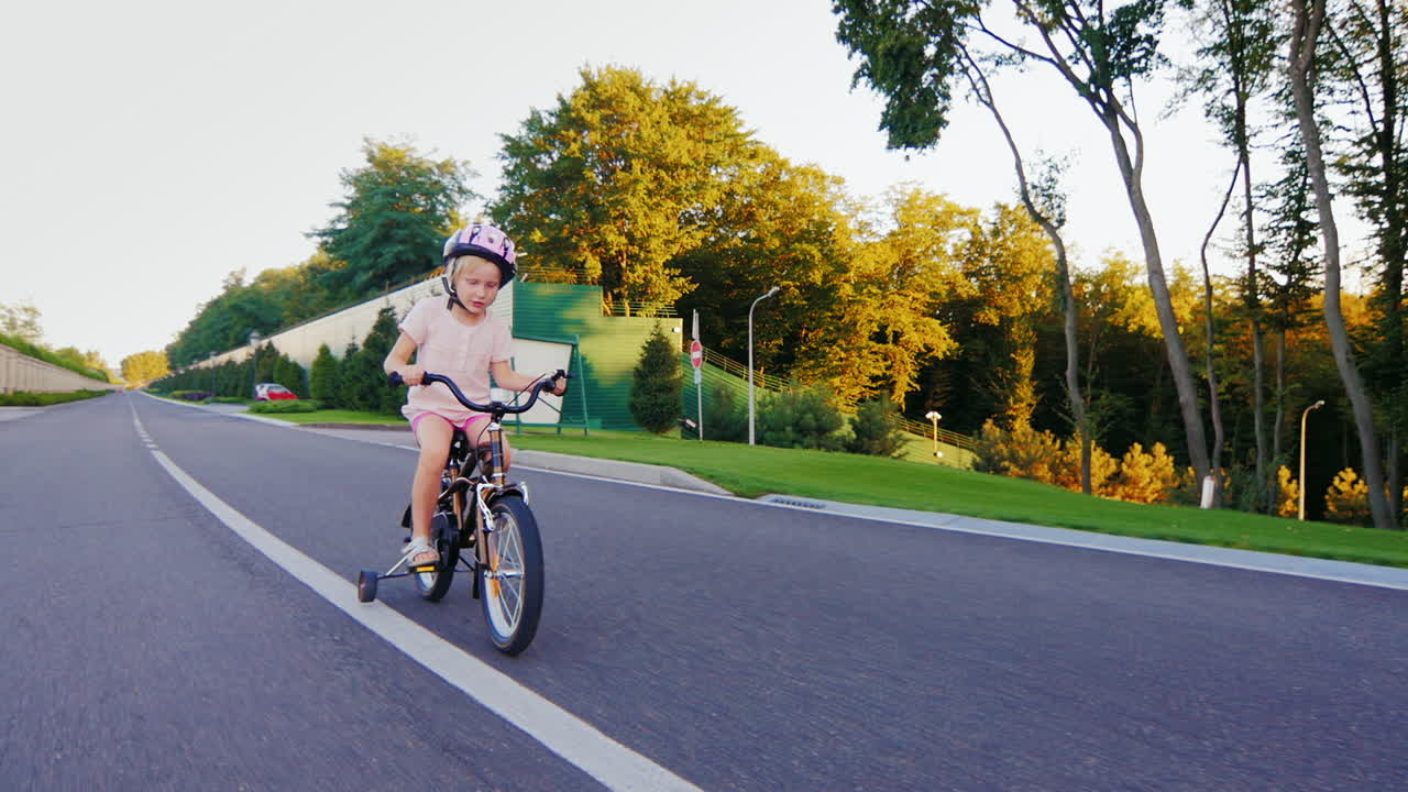 공원에서 자전거를 타는 재미있는 금발 소녀