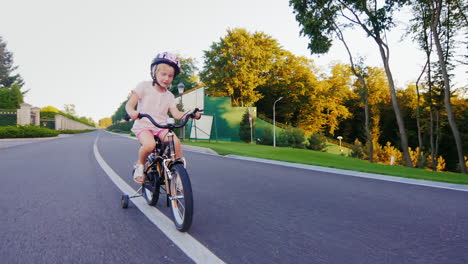 funny blonde girl riding a bicycle in the park