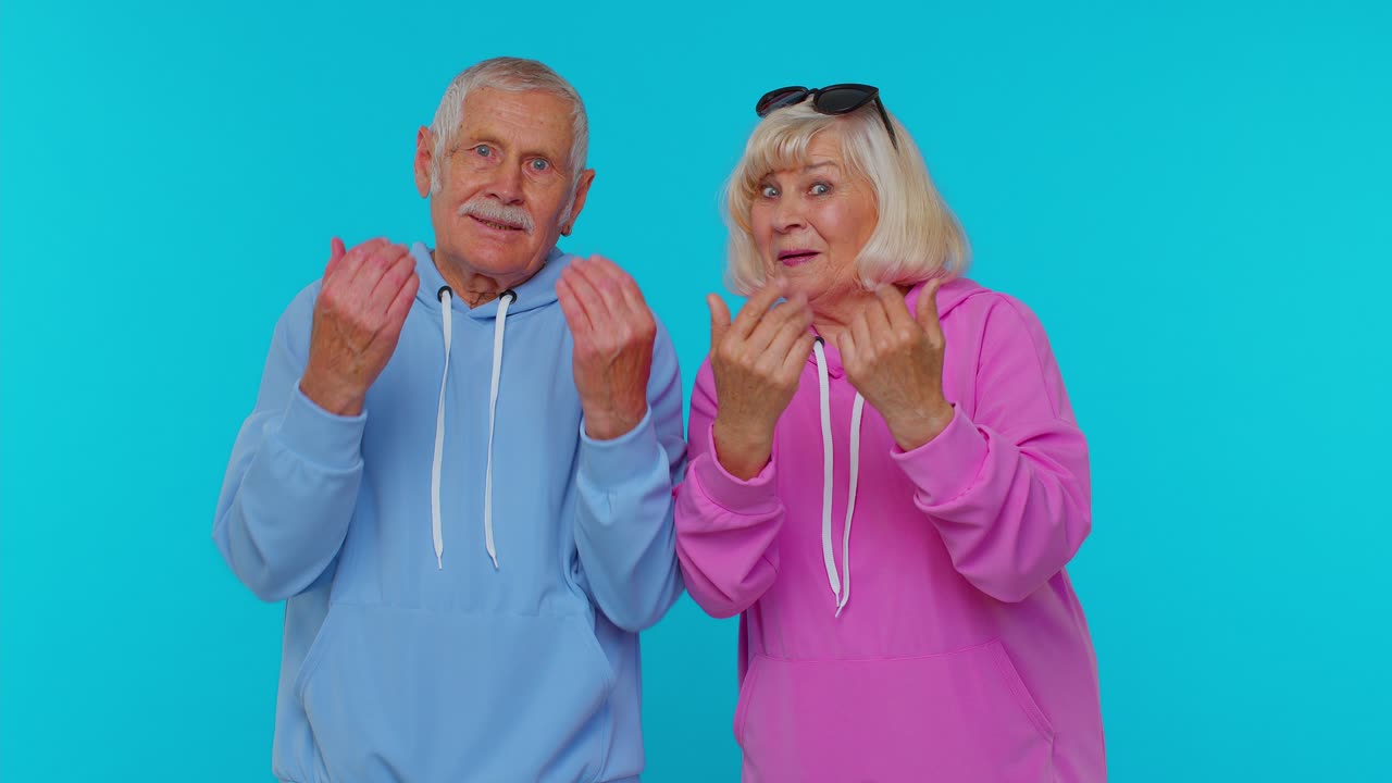Senior grandparents pensioners showing inviting gesture with hands, ask to join, beckoning to coming