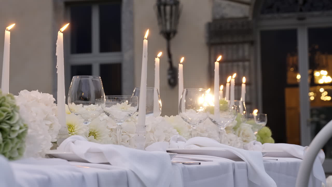 Elegante allestimento della tavola da pranzo all'aperto con candele e fiori