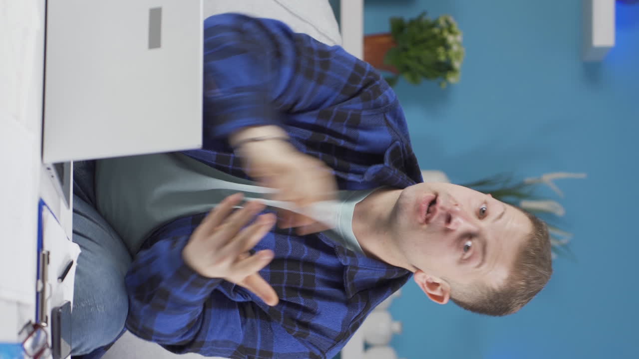 video vertical de un trabajador de oficina en casa mirando a la cámara con una severa advertencia enojada.