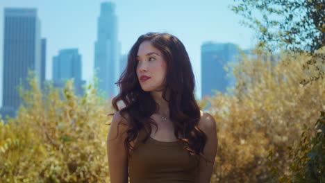 girl looking on camera confidently standing in park. portrait asian female face.