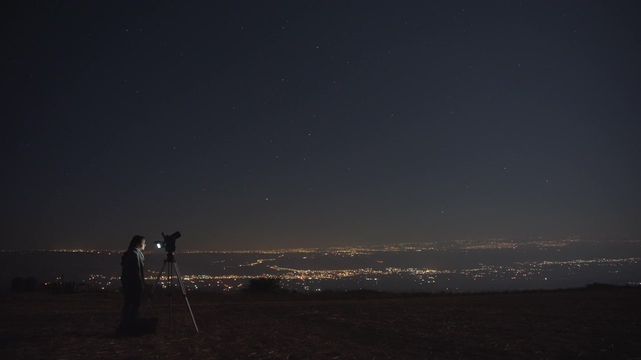 Mulher filmando o céu noturno