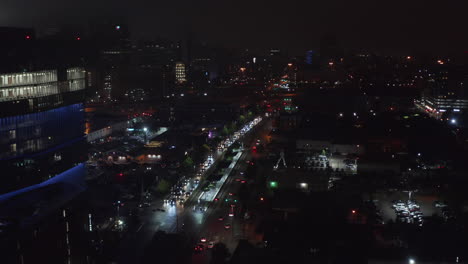 Vista-Aérea-De-La-Concurrida-Carretera-De-Varios-Carriles-Que-Atraviesa-La-Ciudad.-Los-Delanteros-Vuelan-Por-Encima-De-Los-Coches-Que-Conducen-Lentamente-En-Las-Calles-Nocturnas.-Dallas,-Texas,-Nosotros