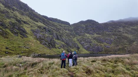 hillwalkers mountainside group of hillwalkers at coumdala lake in the comeragh mountains waterford ireland on a cold winter day