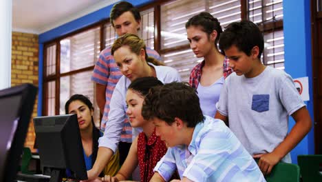 Teacher-assisting-students-in-computer-class