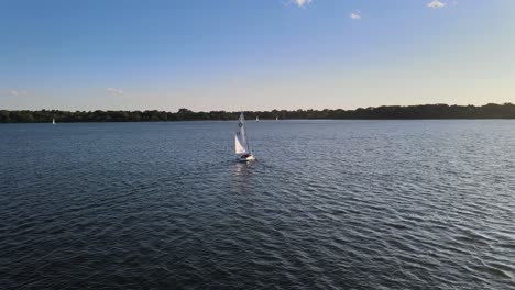 Aerial-view-of-a-sail-boat-going-farther-into-the-horizon