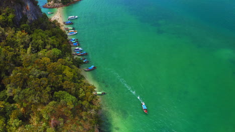 bote de cola larga que se aleja de la isla, tailandia, aéreo, inclinación de la cámara