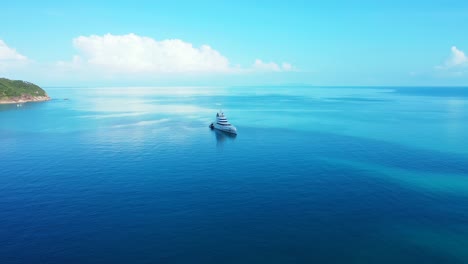 mega yacht floating on calm blue sea lagoon near beautiful thai coastline of tropical island on a summer sunny day