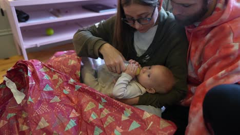 parents feeding baby with bottle