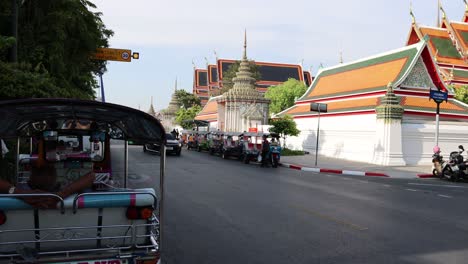 traffic and pedestrians by a colorful temple