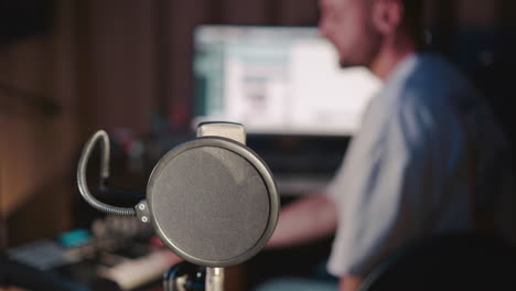 el director de sonido trabaja en un estudio de grabación. el hombre ajusta la pista de audio con la consola de mezcla y la computadora se centran en el micrófono. proceso de producción de música