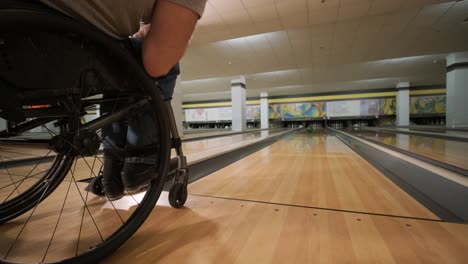 two young disabled men in wheelchairs playing bowling in the club