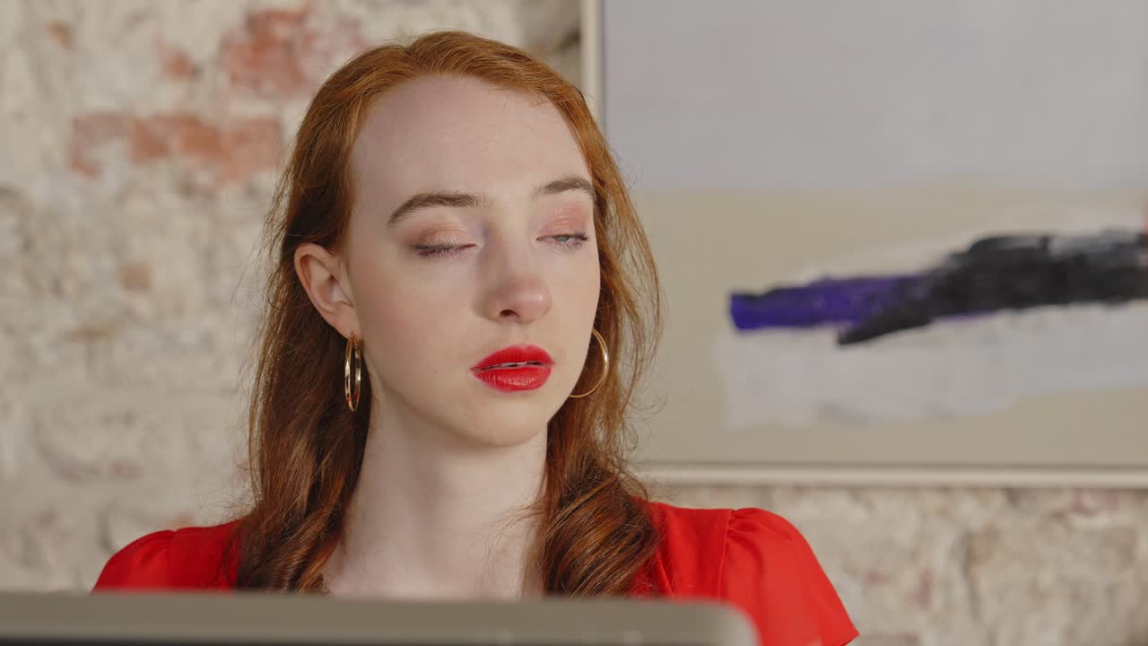 Close up of A young receptionist reacts in shock when a visitor tries to intimidate her. She tries to deescalate and smiles