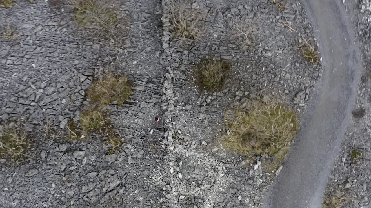 한 사람이 노크마 언덕 꼭대기에 있는 핀바라 성 유적을 하향식 공중으로 걸어갑니다.