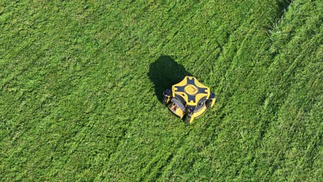 Drohnenaufnahme-Eines-Modernen-Roboter-Rasenmähers,-Der-Sich-An-Einem-Sonnigen-Tag-Auf-Einer-Grünen-Wiese-Bewegt