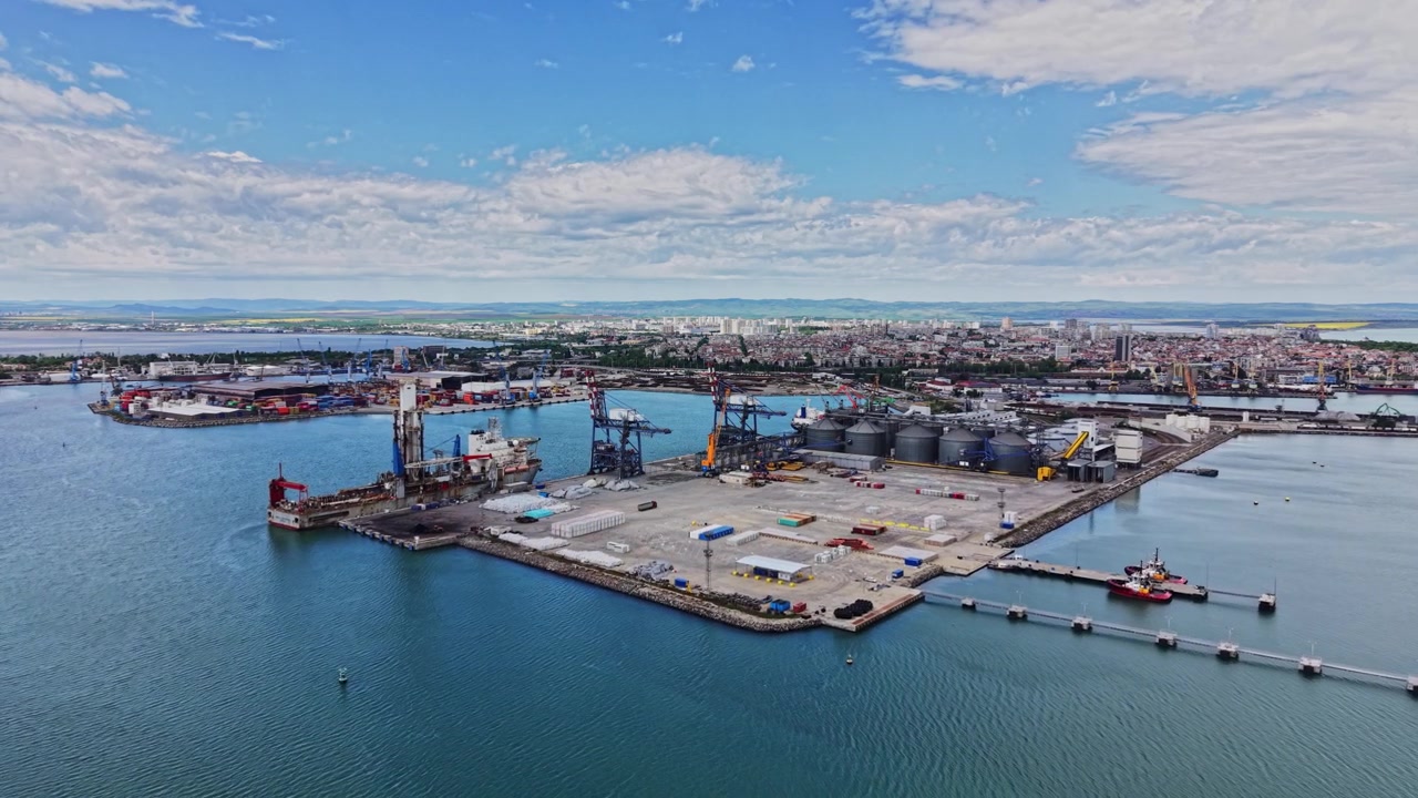 View of a busy port showing ships and city skyline during daytime
