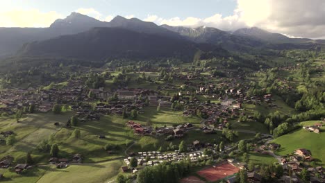 aerial drone footage dolly left to right of beautiful sunset view of grindelwald village in the swiss alps