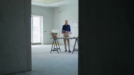 architect reviewing plans at a construction site