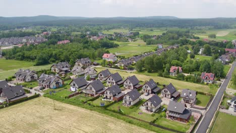 aerial shot of modern neighborhood and fields at summertime