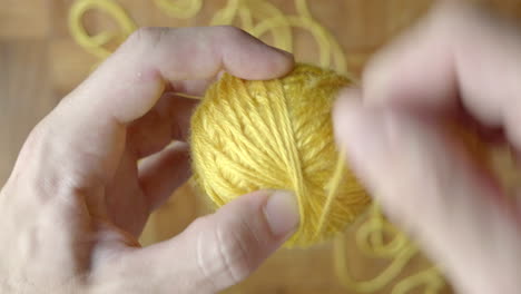 close up of hand winding ball of wool