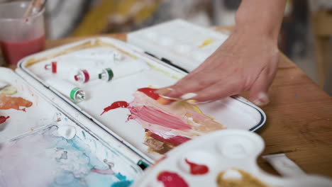 mujer mezclando colores en la paleta