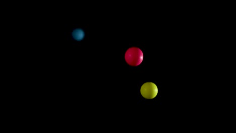 vibrant balls bouncing against a black background