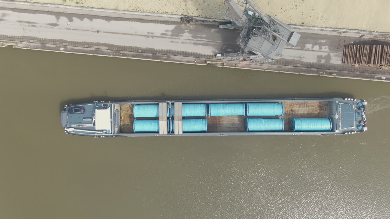 arriba abajo de un barco de carga dejando el puerto un río en la parte superior es una grúa